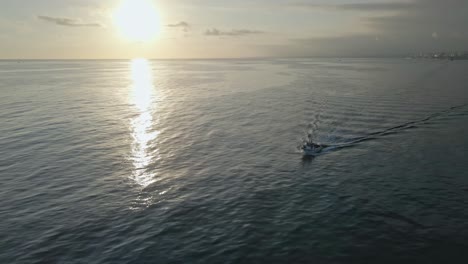 Aerial-view-of-boat-passing-by-during-sunset