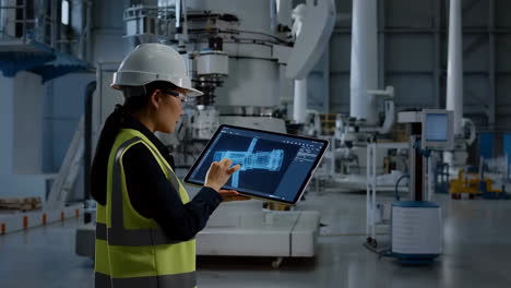 female engineer using tablet with 3d model in a modern factory