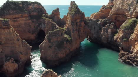 idyllic grottos and rocky eroded archways near ponta da piedade, lagos, algarve, portugal - aerial low orbit shot