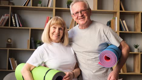 senior couple standing at home with fitness yoga mats senior couple standing at home with fitness yoga mats healthy lifestyle concept morning sports training