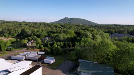 aerial low flight toward pilot mountain nc, north carolina with forest in the foreground and mountain in the background, the pinnacle in the background