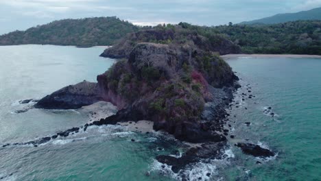 Aerial-of-waves-crashing-against-headland-during-a-cloudy-summer-day