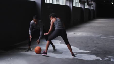 Hombre-Y-Mujer-Afroamericanos-Parados-En-Un-Edificio-Vacío-Jugando-Baloncesto