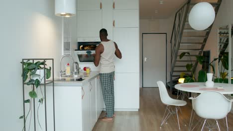 man cooking and cleaning in modern kitchen