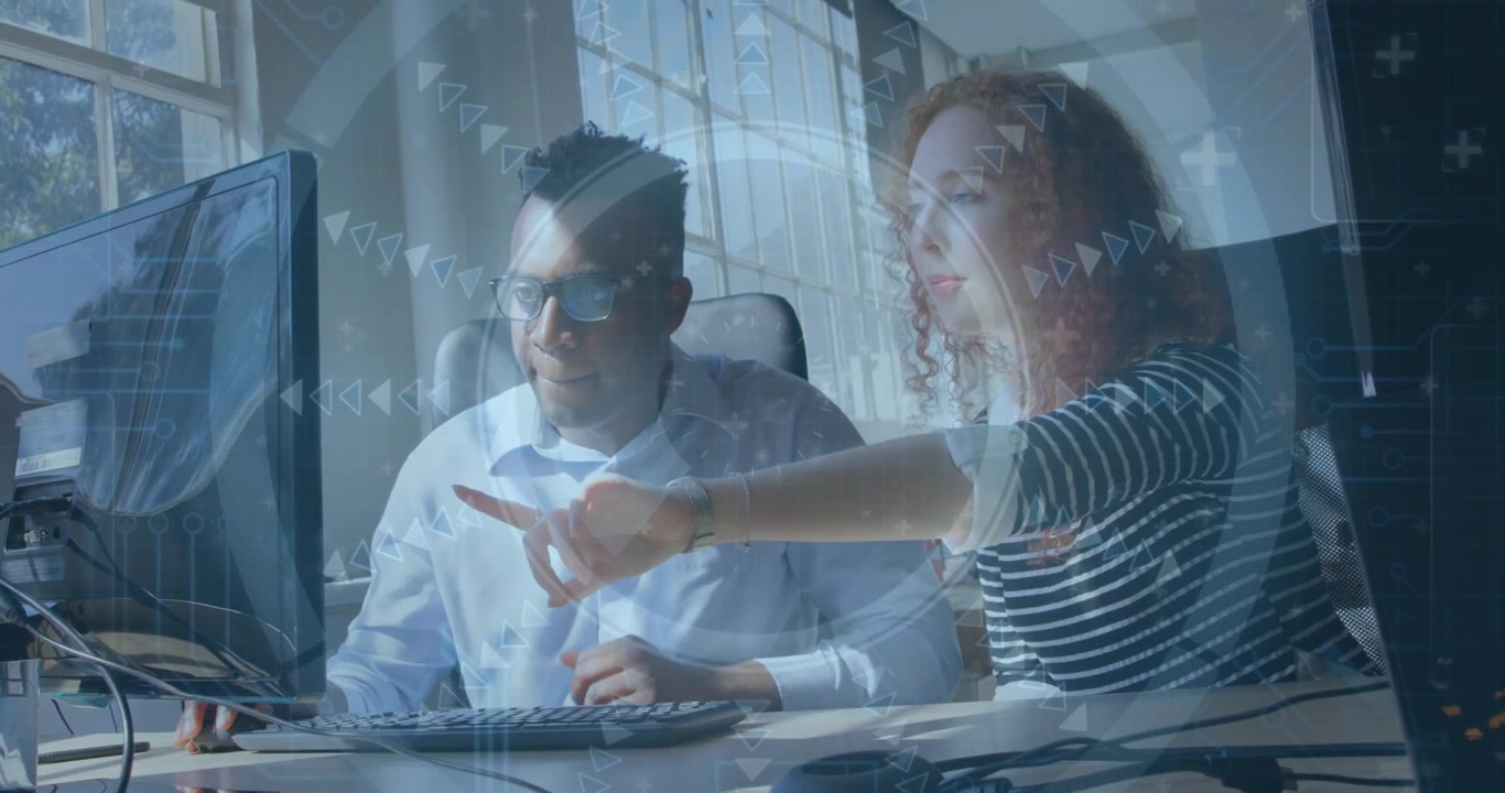 Woman pointing at monitor, guiding peer typing at keys, tech HUD overlays appearing, aiding solving