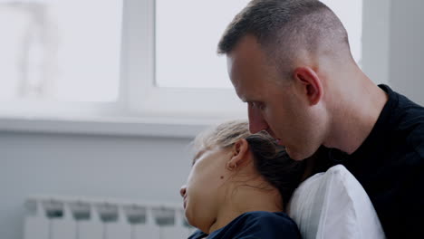 woman sits her back to a man. husband talks to his wife feeling bad from contractions. close up.