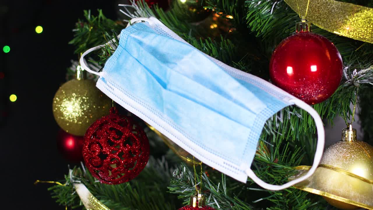 크리스마스 트리에 초점을 맞추는 얼굴 마스: 코로나19 예방 크리스마스