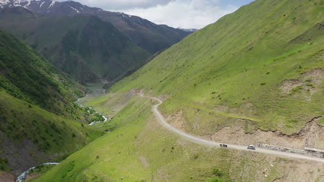 rotating drone shot of a road in the caucasus mountains leading to juta georgia