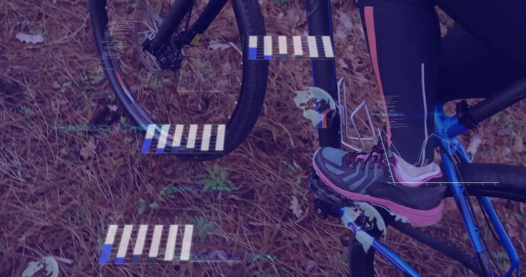 Cyclist shifting forward, pressing pedal and pedaling bike while overlay tracking live stats