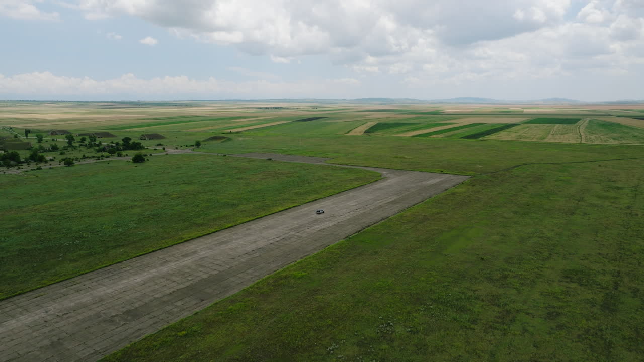 Bil kører på asfaltlandingsbane ved Big Shiraki militærflybase, Georgien