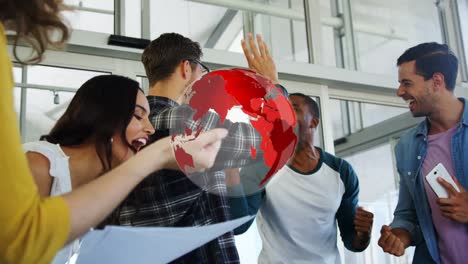 animation of globe over diverse group of happy business colleagues high fiving