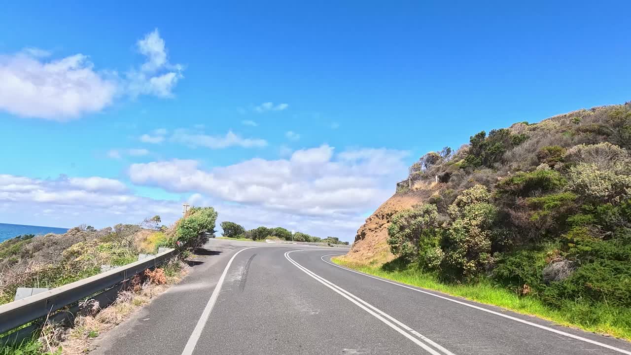 A 14-second video captures a sunny drive along the winding Great Ocean Road, showcasing lush greenery and ocean views