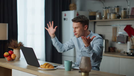 Man-chatting-friends-zoom-sitting-at-kitchen.-Guy-communicating-on-video-call.