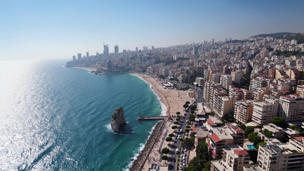 Aerial view of a coastal cityscape with skyscrapers and beach. Captured from a high angle