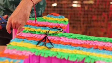 Adding-details-to-the-donkey-shaped-piñata-by-cutting-the-paper