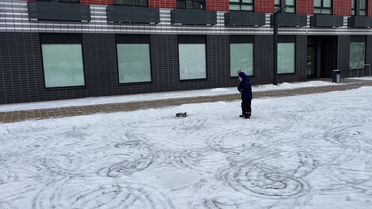 Child playing with remote control car in the snow
