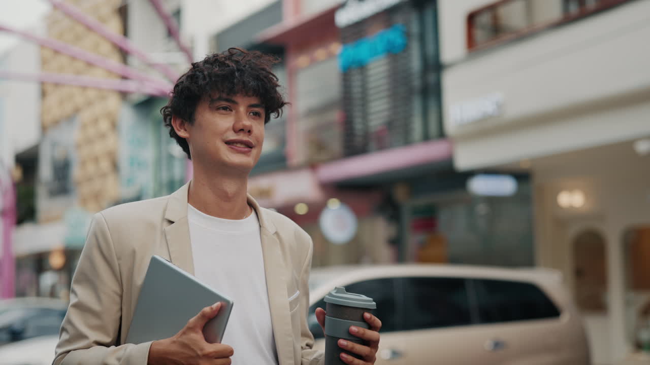 Man with laptop and coffee on city street