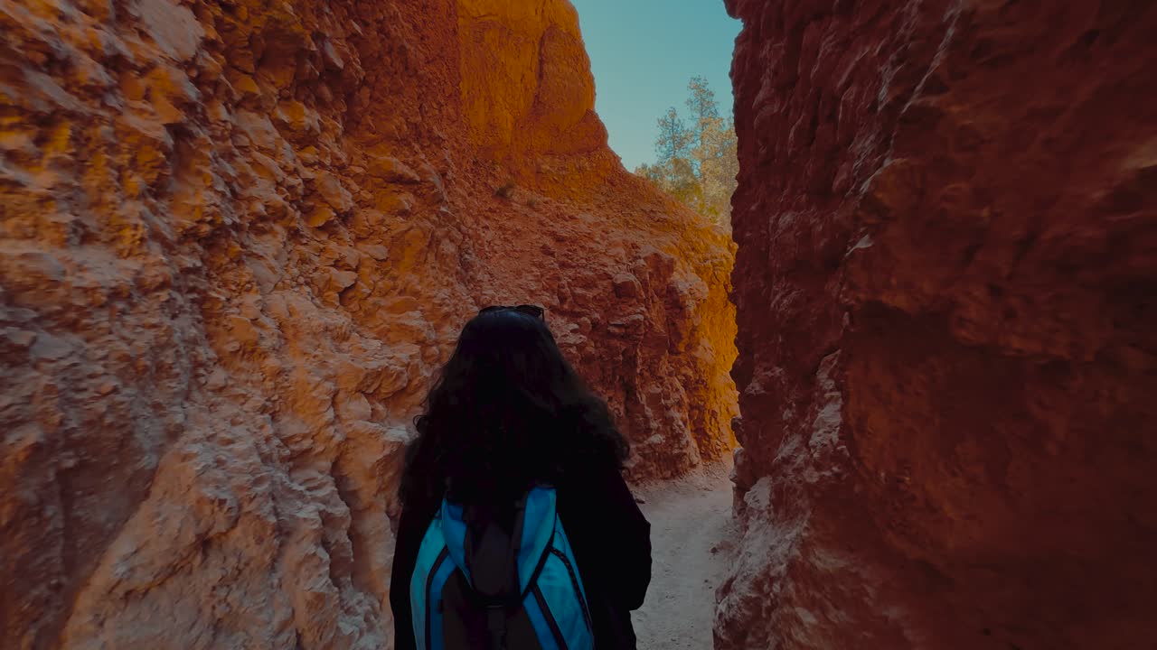 joven mujer morena haciendo senderismo en el parque nacional bryce canyon en utah con hoodoos y roca de arenisca roja