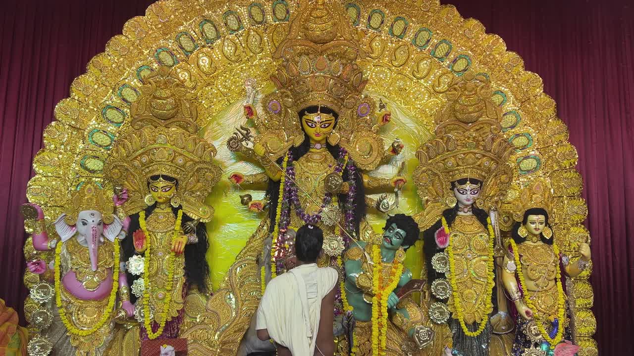A priest is offering Sandhi puja to Goddess Maa Durga in a traditional look in a pandal in Kolkata.