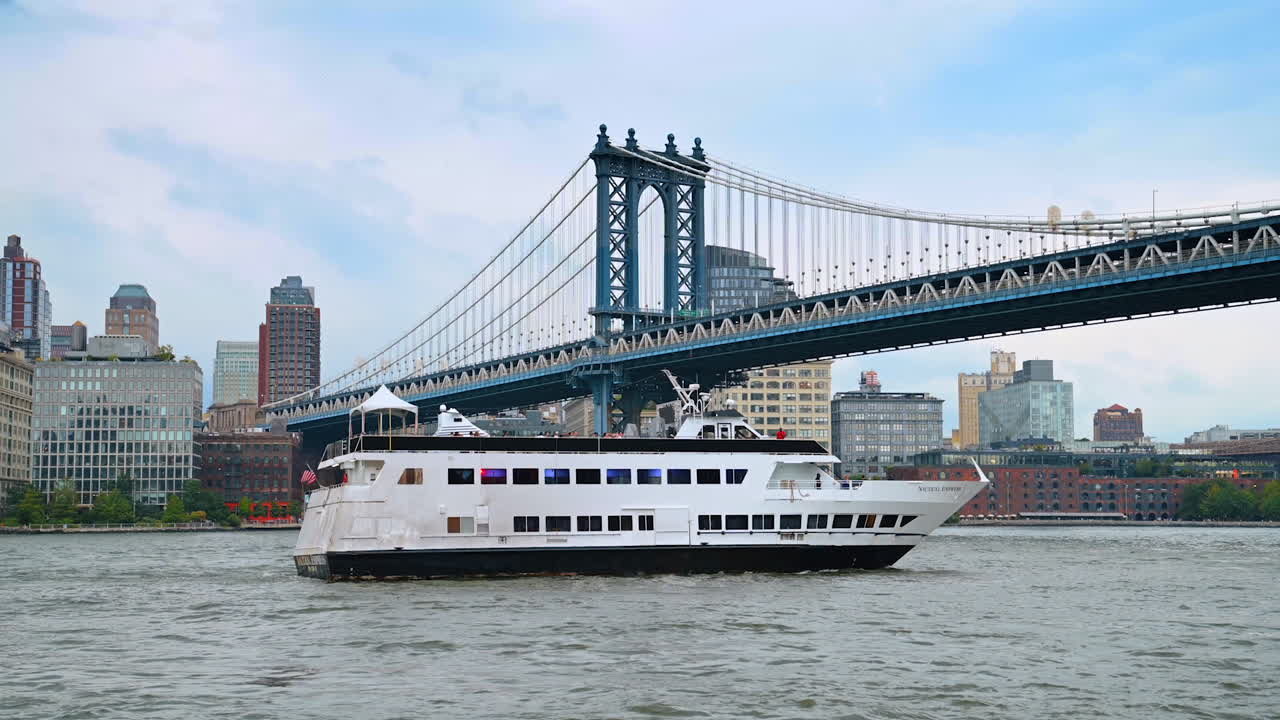 New York, USA, 1 August 2025: Cruise ship on the East River near Manhattan Bridge. A large white cruise ship sails past the Manhattan Bridge with New York skyscrapers in the distance