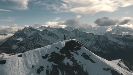 a male person stands on the summit and enjoys the mountainscape - italian alps in south tyrol