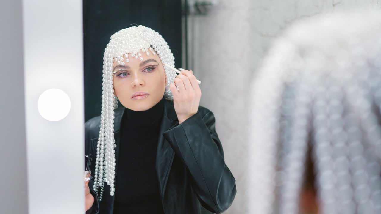 Woman with Pearl Headpiece Applying Makeup in Mirror