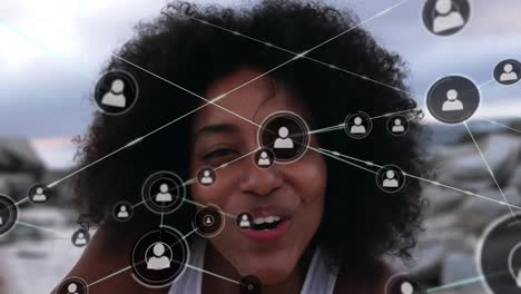 Animation-of-network-of-connections-with-people-icons-over-woman-in-beach