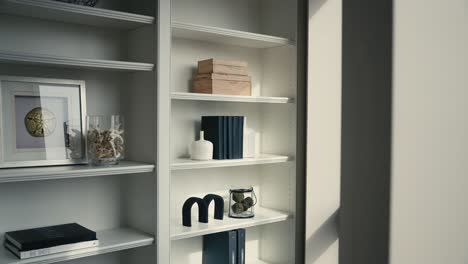 neatly decorated white shelving next to a window letting in natural sunlight