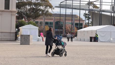 a mother pushing a pram outdoors