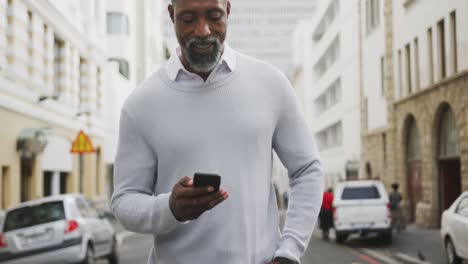 Afroamerikanischer-Mann,-Der-Sein-Telefon-Auf-Der-Straße-Benutzt