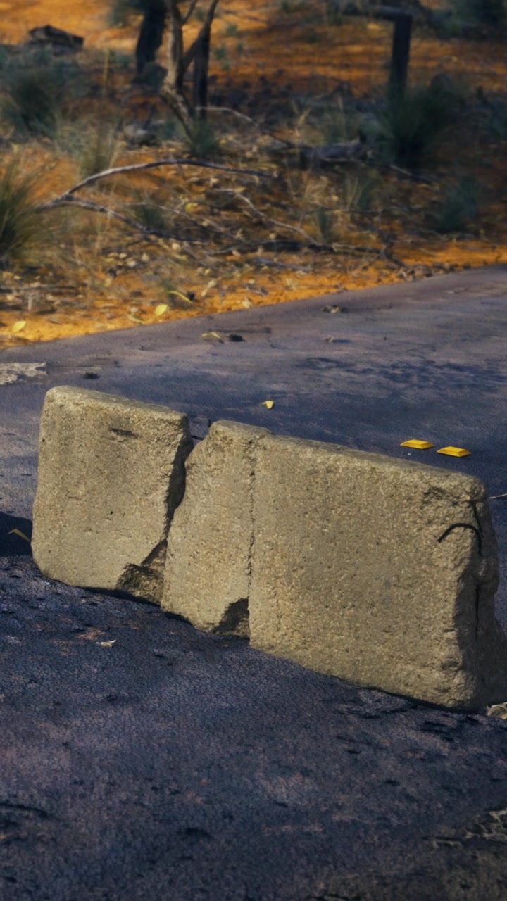 Blocchi di cemento posizionati su strada asfaltata in un'area esterna durante il giorno