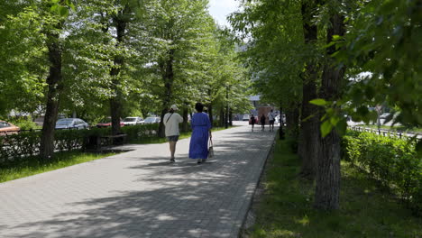 people walking in a city park on a sunny day