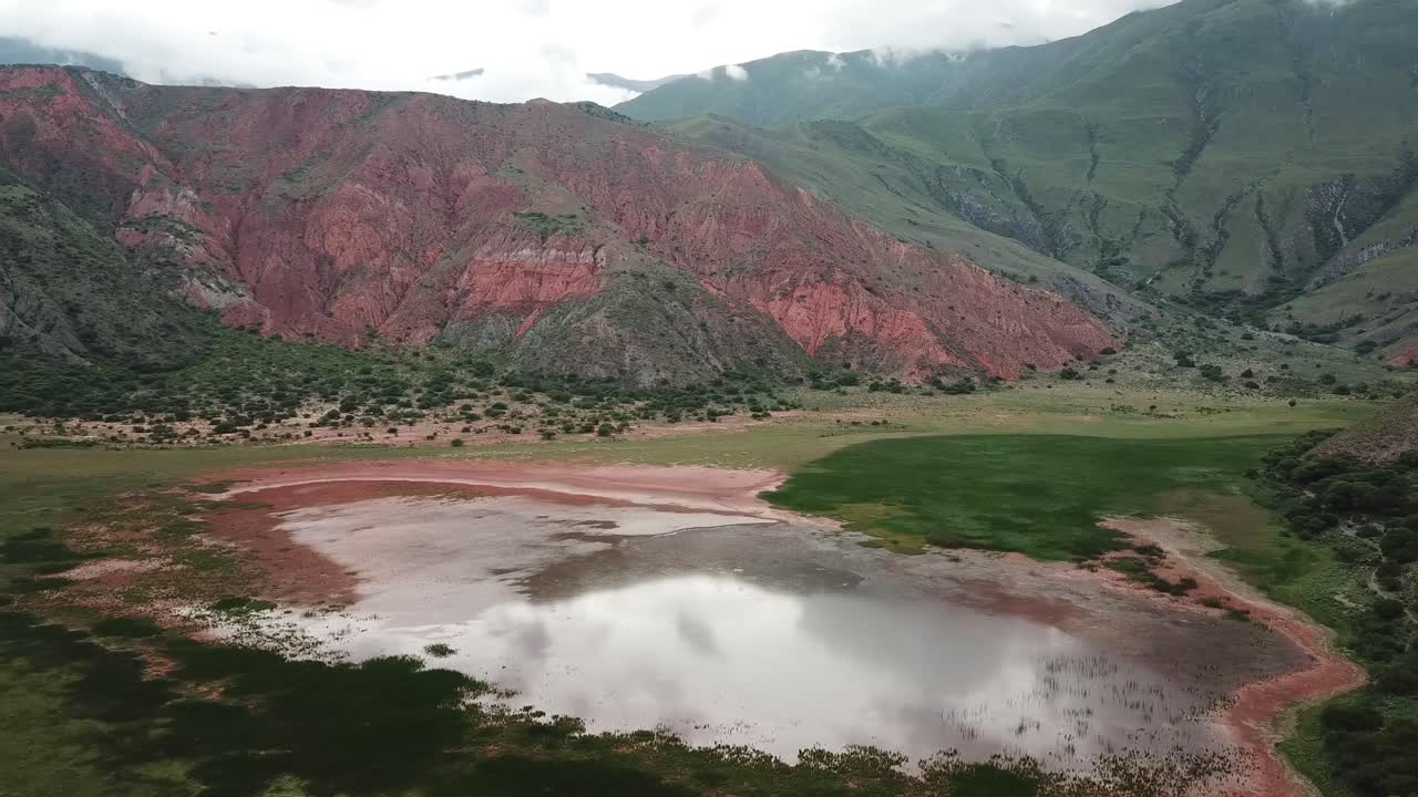 Aerial View of Shallow Pond in Scenic Valley Under Red and Green Hills. Jujuy Province, Countryside of Argentina