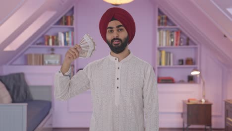 egoistic sikh indian man using money as fan with cunning smile