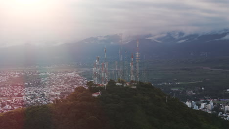 aerial track shot of mountain top antennas with salta, capital city of argentina beyond