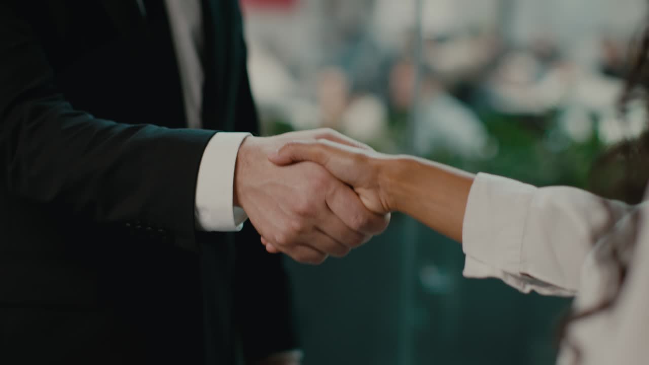 hombre de negocios y mujer de negocios estrechando la mano en acuerdo en la oficina, recortado