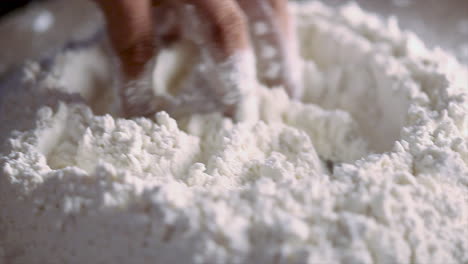 mixing of salt and wheat flour for making dough by chef on a kitchen