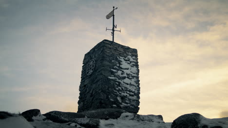 static shot of a weathervane spinning in the wind at the top of lovstakken at sunrise