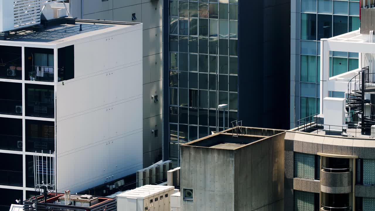 vista de las ventanas del edificio en la ciudad de osaka, japón, con autos reflejados que pasan en un nivel más bajo, tiro alto estable
