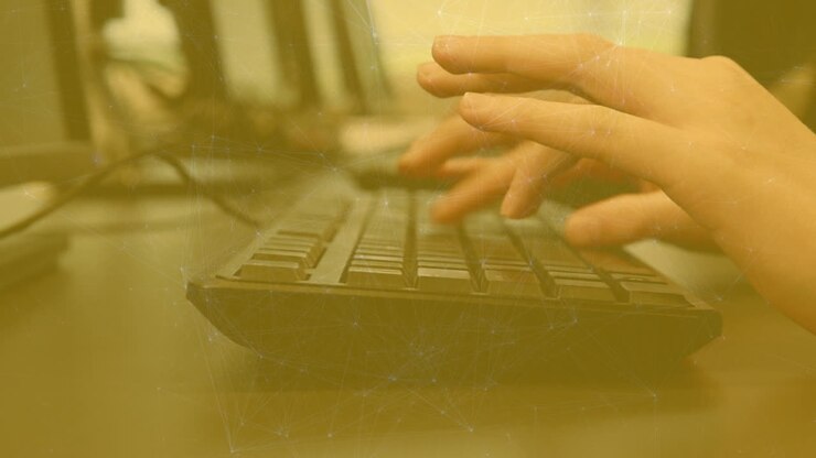 Animation of network of connections against close up of hands typing on keyboard
