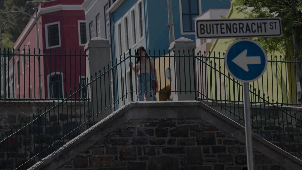 Folk går på trapper i farverig Bo-Kaap gade, Cape Town