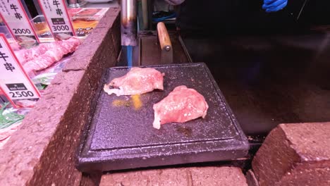 sequential cooking of meat on a heated stone.