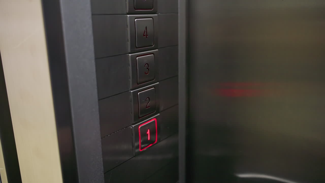 Close-up of hand pressing elevator button on metal panel. Focus on finger activating button for second floor in modern lift. Ideal for videos related to technology, office settings