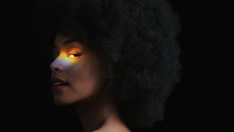 Nahaufnahme-Eines-Mehrfarbigen-Porträts-Einer-Schönen-Afroamerikanischen-Frau-Mit-Afro,-Die-Einen-Glatten,-Gesunden-Teint-Genießt-Und-Selbstbewusst-Aussieht,-Natürliche-Schönheit,-Buntes-Licht-Auf-Schwarzem-Hintergrund,-Hautpflegekonzept