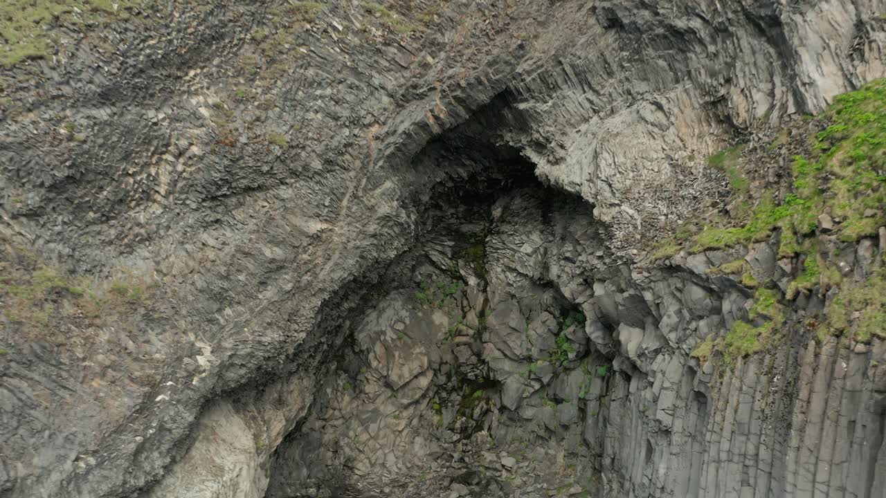 volando lejos de la pared de roca en la costa de la playa de reynisfjara, islandia