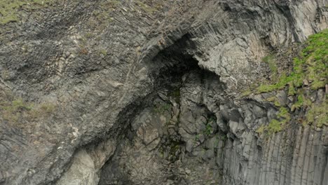 Volando-Lejos-De-La-Pared-De-Roca-En-La-Costa-De-La-Playa-De-Reynisfjara,-Islandia