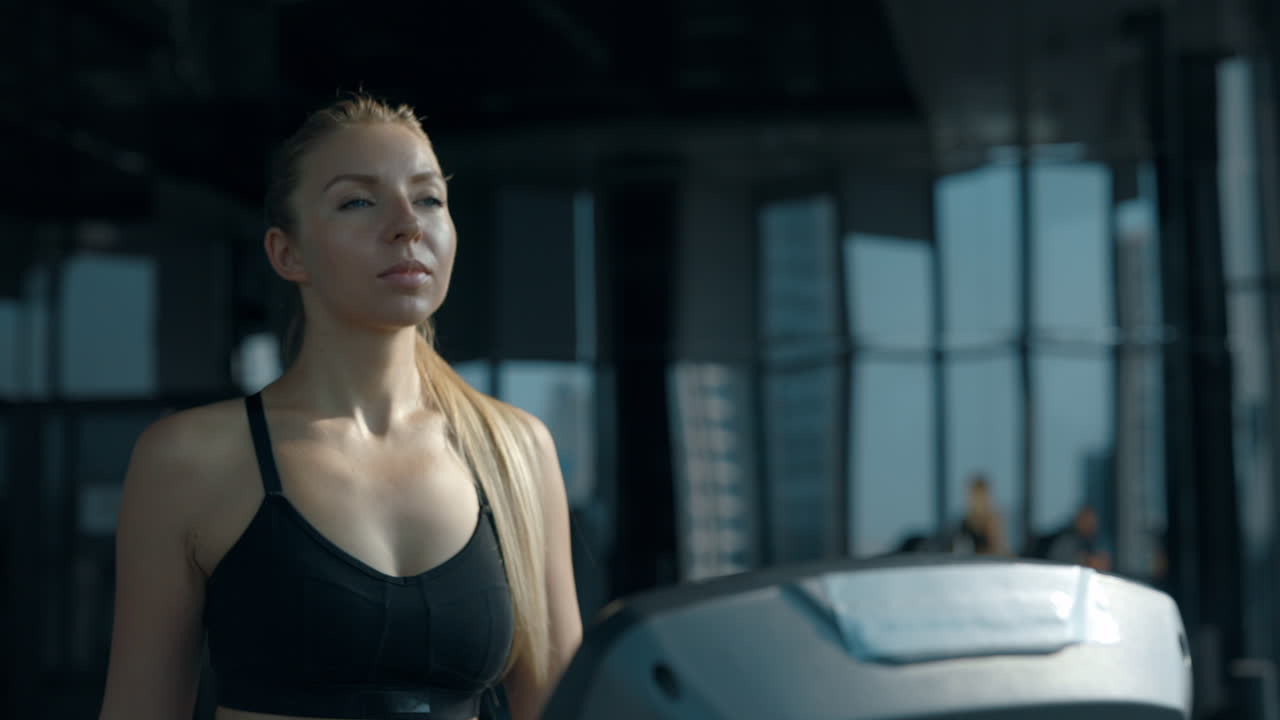 A woman exercising on a treadmill in a modern gym