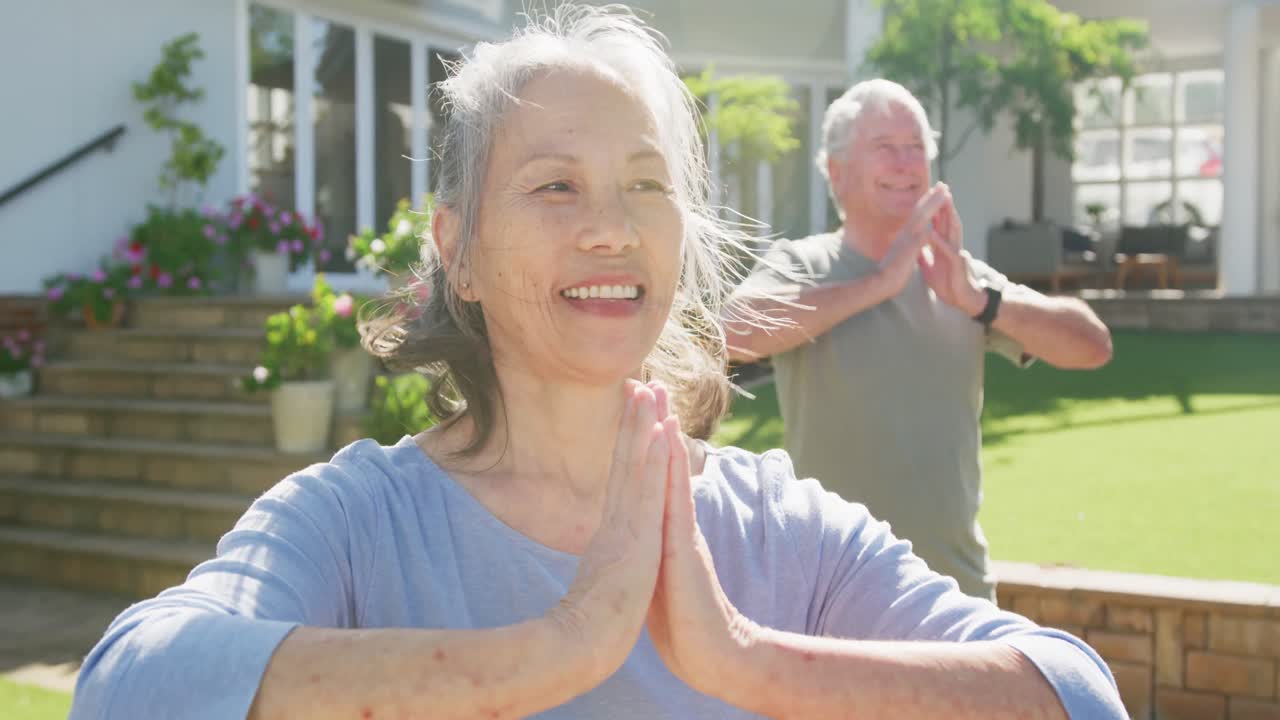 다양한 행복 한 노인 부부는 정원에서 이 좋은 날에 요가를 연습합니다.