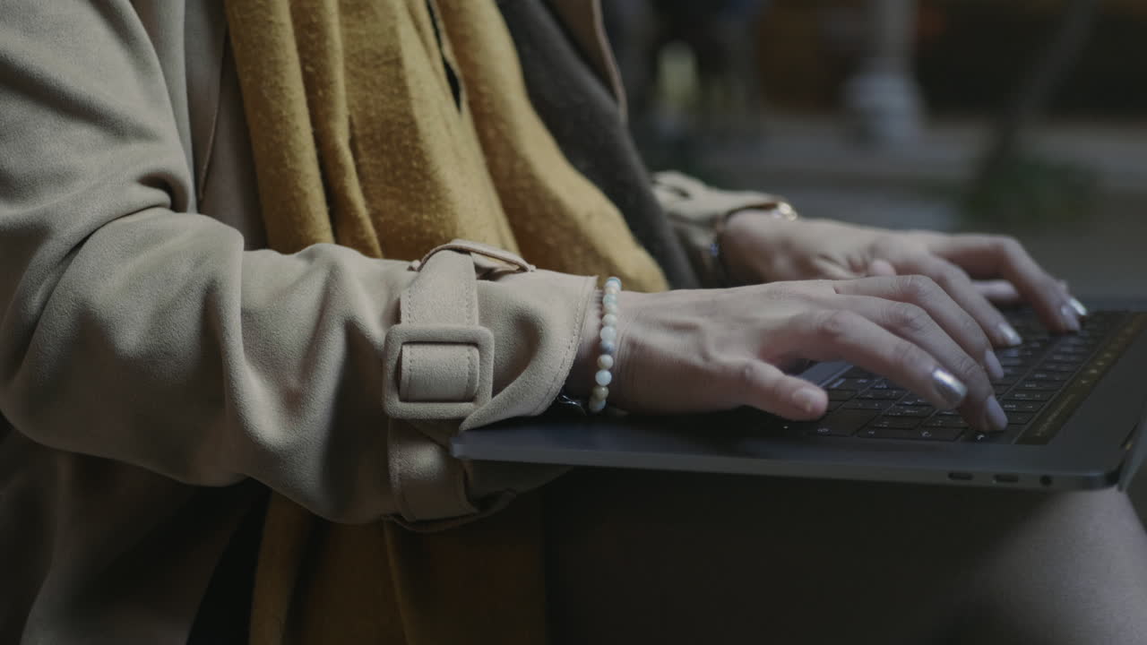 야외에서 노트북에서 터치패드를 사용하는 학생. 여자 손은 밖에서 노트북을 타이핑합니다.