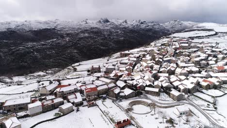 Dorf-Mit-Schneebedeckten-Bergen-Aus-Der-Luft